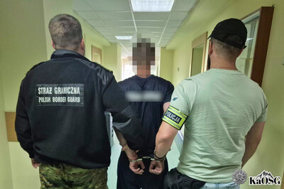 Na zdjęciu widać trzy osoby. Osoba w środku jest zatrzymana i prowadzona