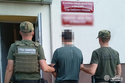 Zatrzymany cudzoziemiec jest prowadzony do siedziby grupy zamiejscowej w oświęcimiu przez dwóch funkcjonariuszy sg