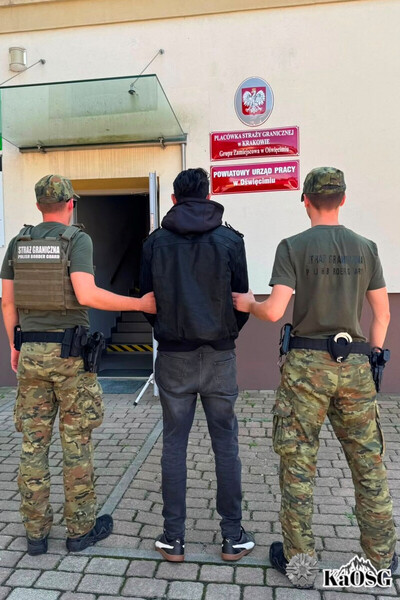 cudzoziemiec prowadzony jest przez dwóch funkcjonariuszy do siedziby grupy zamiejscowej w oswięcimiu