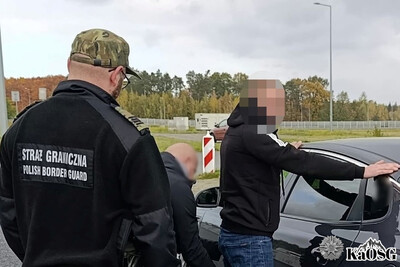 Zatrzymany obywatel Mołdawii jest przeszukiwany przy samochodzie przez strażników granicznych